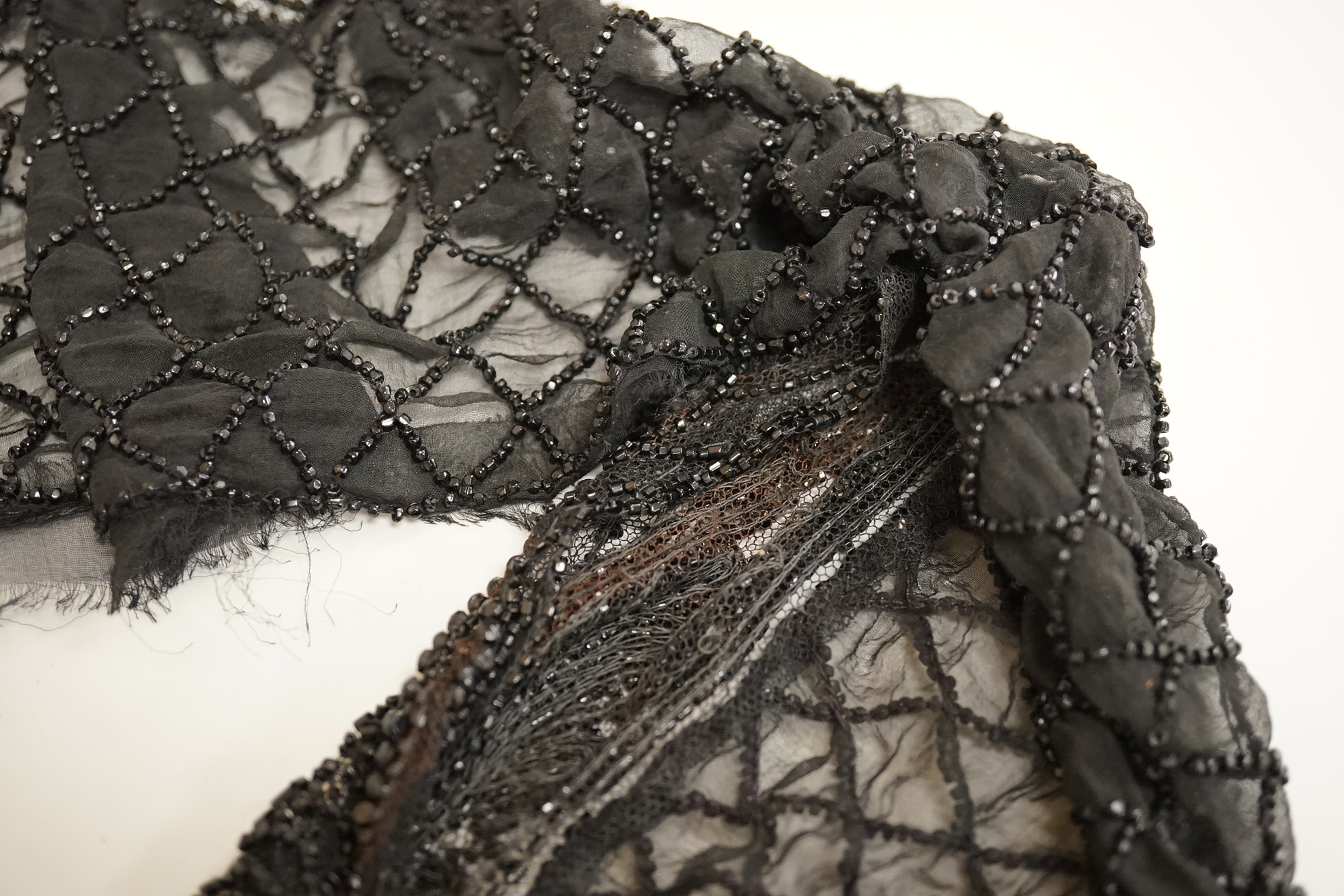 A cut steel fronter, a jet beaded panel, a pair of fringed black suede gauntlets, a seed pearl headdress, etc.